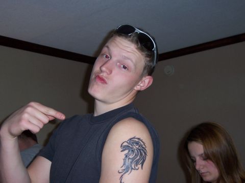 1998 Jeep TJ - A young man with an eagle tattoo on his arm and sunglasses perched on his head poses for a photo.