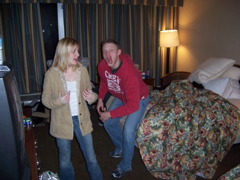 1998 Jeep TJ - Two people are posing in a hotel room, with a bed and television visible.