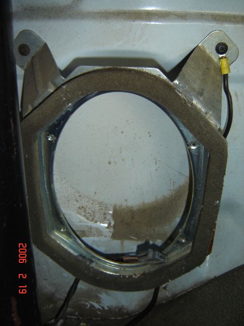 1993 Ford Bronco - A speaker mounting bracket is shown with its foam seal and electrical connections. The surrounding surface is dusty.