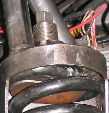 1984 Ford Bronco - Detail of vehicle suspension components, including a coil spring and adjustment bolt.