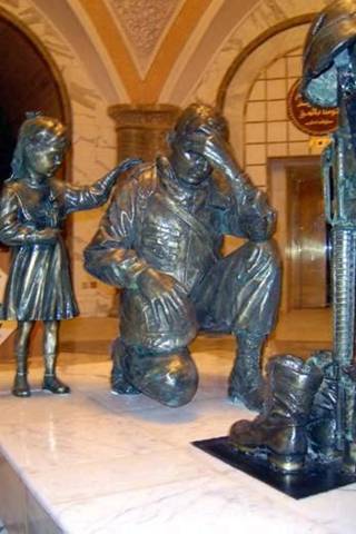 1992 Ford C-250 (Centurion Conversions) - Statue depicting a soldier and a child, possibly a memorial.