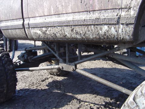 1987 Suzuki Samurai - The undercarriage of a heavily muddied vehicle is shown, with large tires and suspension parts visible.