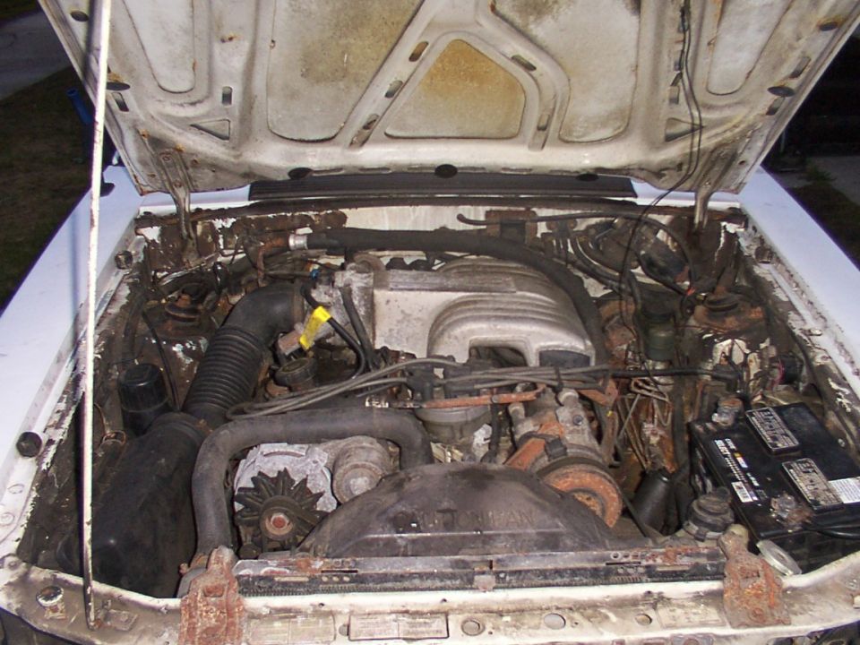 1988 Ford Mustang engine bay with V8 engine, alternator, and battery