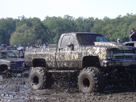 1987 Suzuki Samurai - Pickup truck covered in mud during an off-road event.