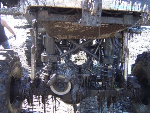1987 Suzuki Samurai - The underside of a heavily modified off-road vehicle is caked in mud after an off-road excursion.