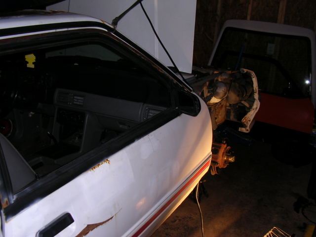 1988 Ford Mustang interior and engine bay, with another vehicle visible in the background