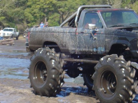 1987 Suzuki Samurai - Modified pickup truck with large tires participating in a mud bogging event.