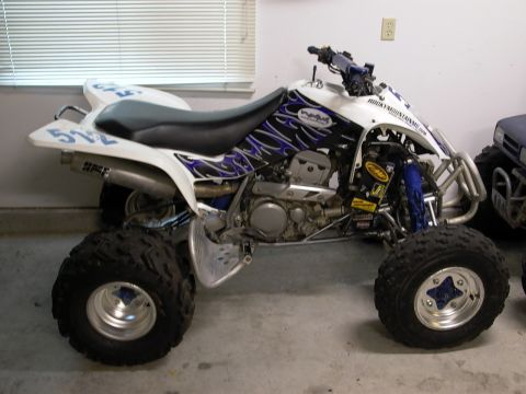 2003 Suzuki LTZ400 - A white quad with blue flame graphics is parked indoors, showing its side profile.