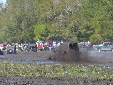 1987 Suzuki Samurai - Mud bogging event with multiple off-road vehicles and spectators.