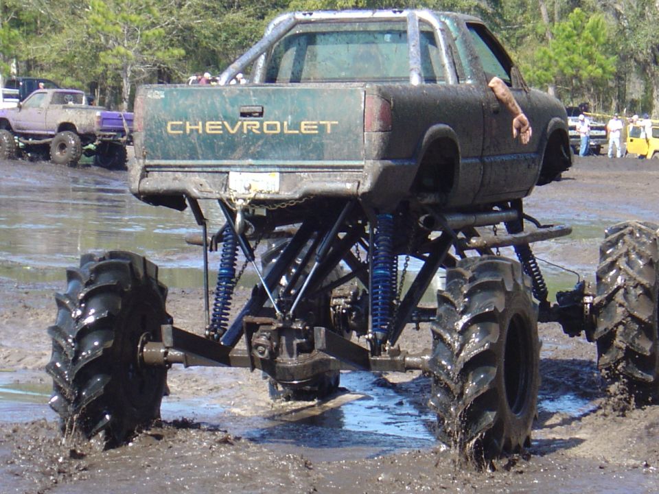 Lifted Chevrolet pickup truck with large tires in mud