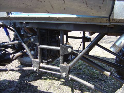 1987 Suzuki Samurai - Close-up view of the modified suspension and drivetrain of an off-road vehicle.