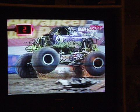 1989 Ford Bronco - A monster truck, identified as "Grave Digger", is captured mid-air during a jump.