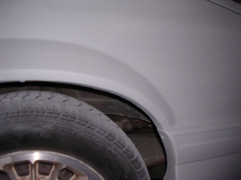 1988 Ford Mustang - The side panel and wheel well of a vehicle are shown in this close-up shot.