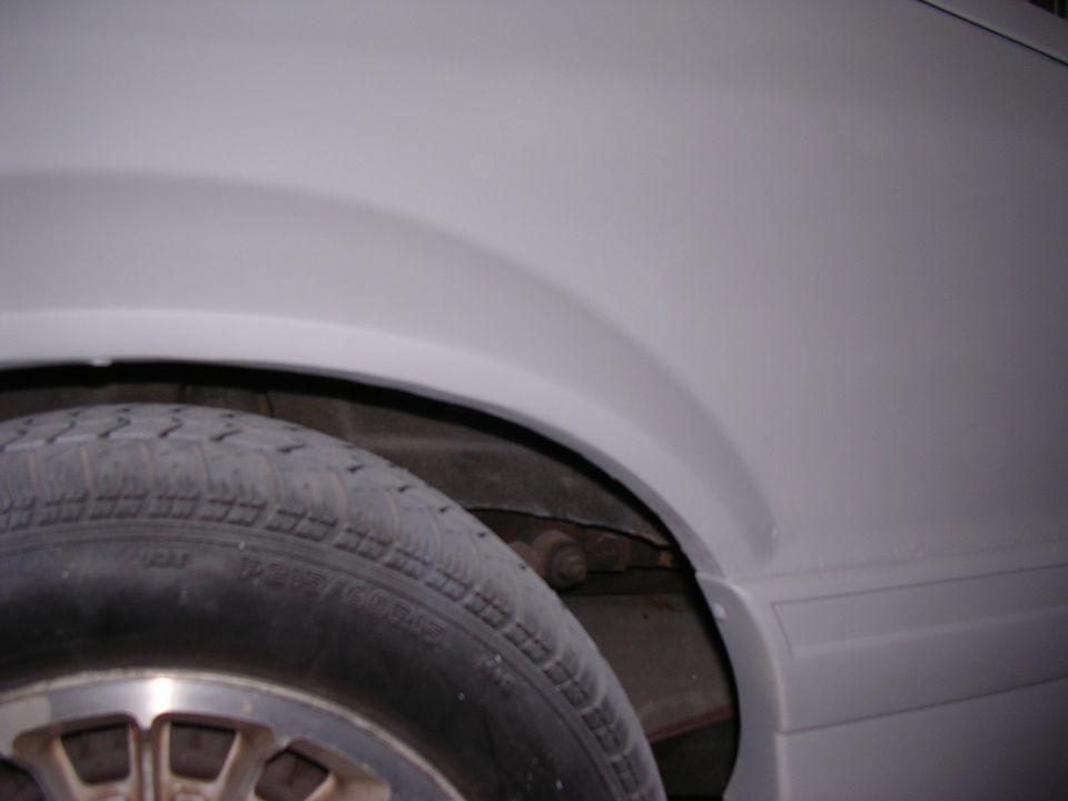 Close-up of a car's rear fender and tire, painted gray