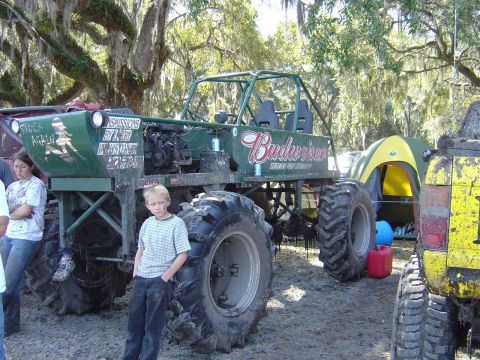 1987 Suzuki Samurai - Custom off-road vehicle with Budweiser branding and large tires, parked outdoors with a tent and another vehicle.