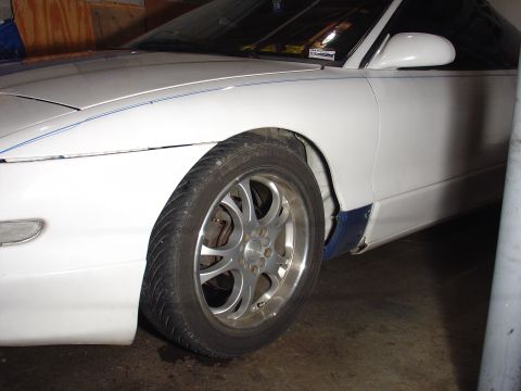 1993 Ford Probe - The front 3/4 view of a white 1993 Ford Probe, custom wheels and a blue accent on the lower body panel.