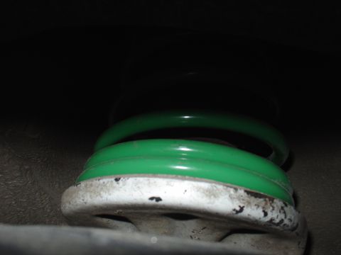 1993 Ford Probe - A close-up shows a green coil spring attached to a white suspension component.