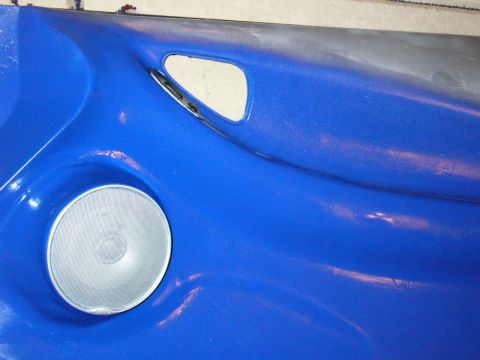 1994 Ford Probe - Close-up of a blue car door panel a speaker and vent detail.