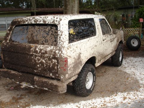 1989 Ford Bronco - This 1989 Ford Bronco is heavily covered in mud, obscuring most details but retaining its distinctive body style.