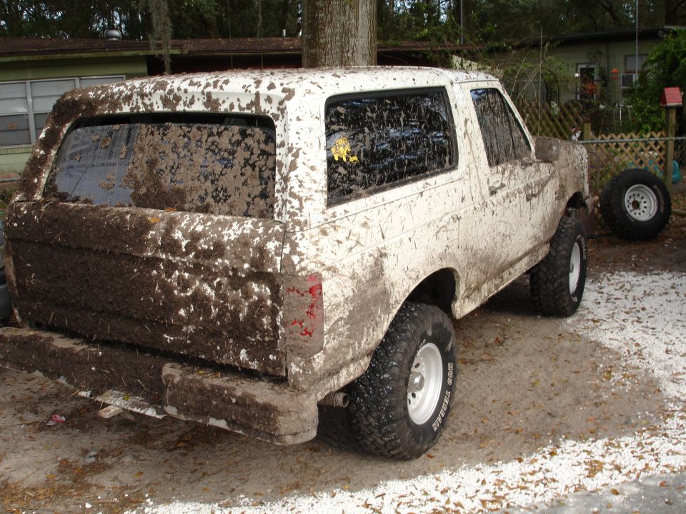 Mud-covered 1989 Ford Bronco, rear 3/4 view