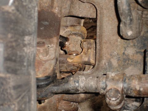 1989 Ford Bronco - This image shows a close-up view of a damaged and rusted vehicle suspension part, indicating a need for repair.