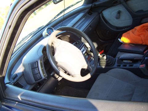 1994 Ford Probe - The interior of a car is shown, a manual transmission shifter and an aftermarket gauge mounted on the dashboard.