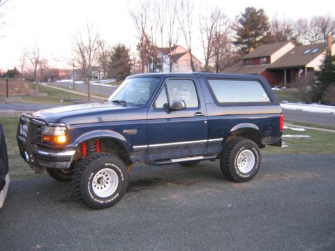 1994 Ford Bronco - This blue 1994 Ford Bronco features a lifted suspension and large off-road tires, giving it a stance.