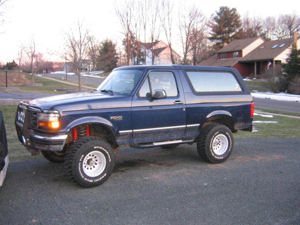 Lifted dark blue Ford Bronco side view on BFGoodrich all-terrain tires and white wheels
