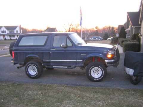 1994 Ford Bronco - Side view of a lifted 1994 Ford Bronco with aftermarket wheels and tires.