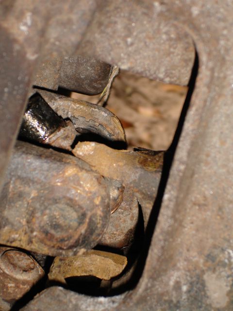 1989 Ford Bronco - This image shows heavily rusted metal parts and bolts, likely from a vehicle's undercarriage.