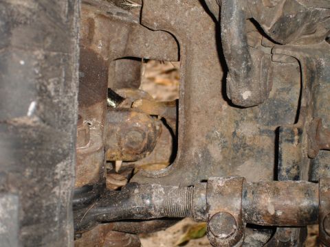 1989 Ford Bronco - This image shows heavily rusted vehicle suspension components, with some visible markings on a metal bracket.
