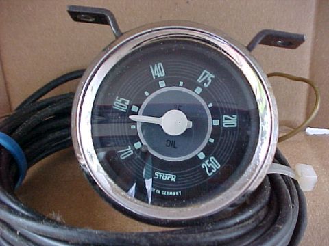 1973 Ford Ranchero - Close-up of a vintage German-made oil temperature gauge with a chrome bezel and black face reading 70 to 250 degrees, mounted on a bracket…