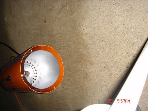 1991 Ford Bronco - An orange engine part is shown with a white curved object in the foreground against a concrete wall.