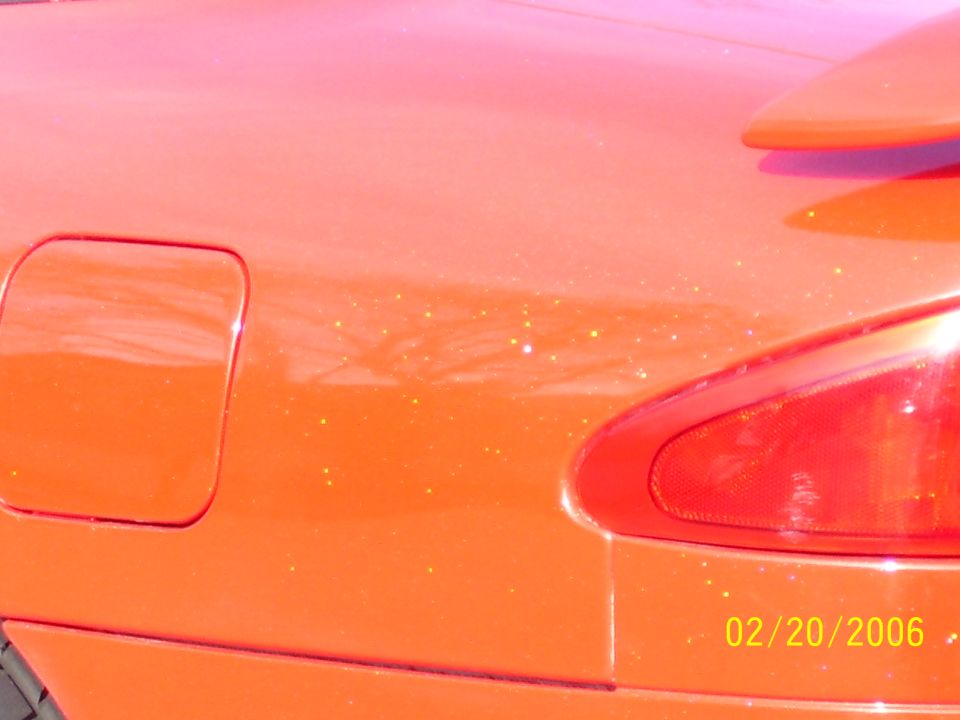 Orange metalflake rear deck and taillight with fuel door of a car, dated 02/20/2006
