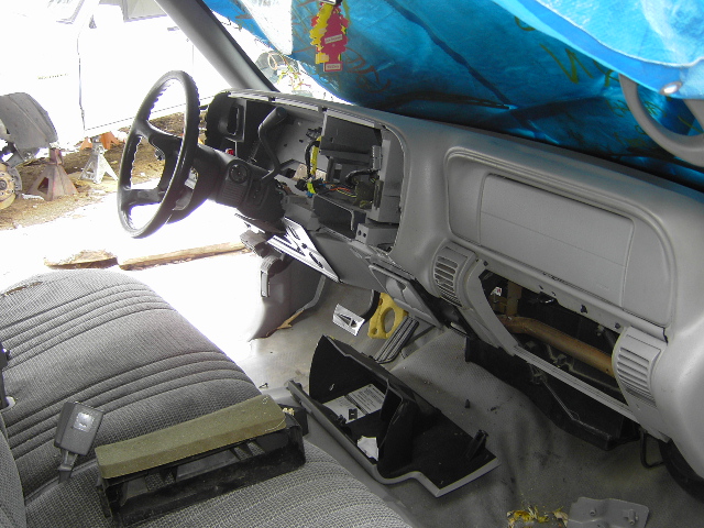 1997 Chevrolet C/K Pickup interior, dashboard removed, seats visible, blue tarp overhead