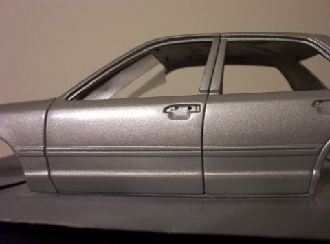 1998 Ford Crown Victoria - Side profile of a silver vehicle, highlighting the door and window structure. The Supermotors.net logo is present in the lower right corner.