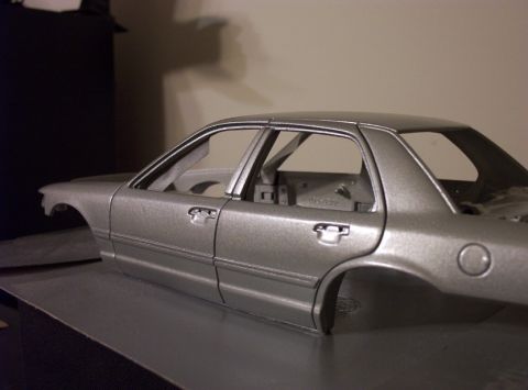 1998 Ford Crown Victoria - This is a model car body, likely a sedan, shown from the side. It appears to be unpainted or primed.