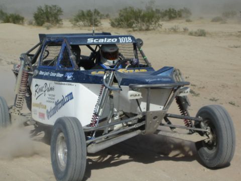 Blue and white off-road race buggy number 1018 with helmeted driver