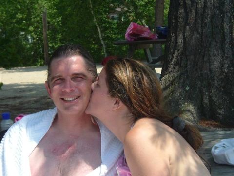 1990 Toyota Celica - A woman kisses a man on the cheek while sitting outdoors near a large tree.