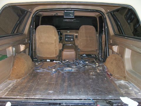 1991 Ford Bronco - The rear of the vehicle is stripped down, showing exposed wiring and the floor panels.