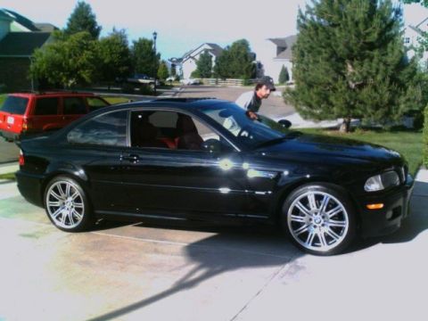 1996 Ford Probe - A black BMW coupe is parked in a driveway with a red SUV in the background.