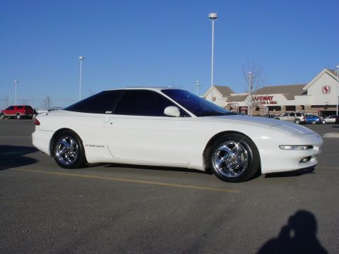 1996 Ford Probe - White coupe with tinted windows and chrome wheels parked in a lot.