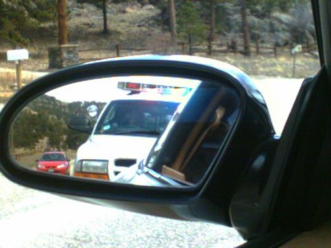 1996 Ford Probe - Reflection in side mirror shows an ambulance and a red car on a road with trees in the background.