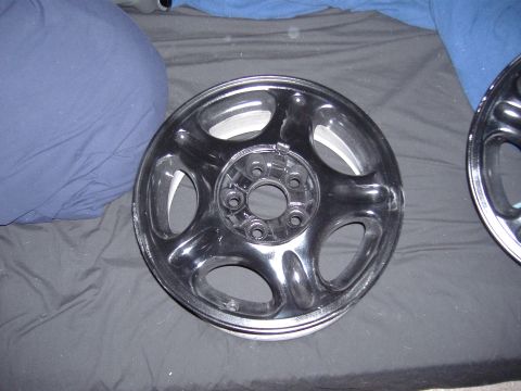 1998 Ford Taurus - A single black alloy car wheel is shown, with another wheel partially visible to the right.