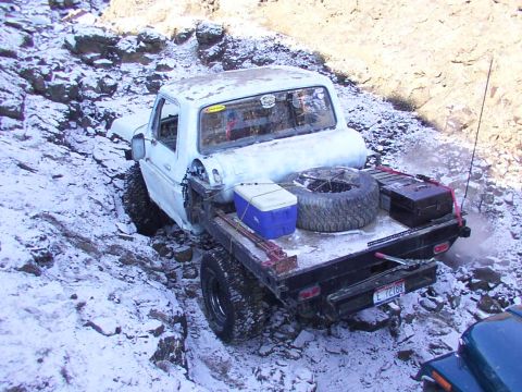 1978 Ford Bronco - This flatbed truck appears to be from the mid-1970s, not a 1978 Bronco, as it navigates a difficult snowy terrain.