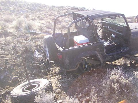 1978 Ford Bronco - This dark-colored SUV appears to be stuck in a muddy environment, with its front end partially submerged.