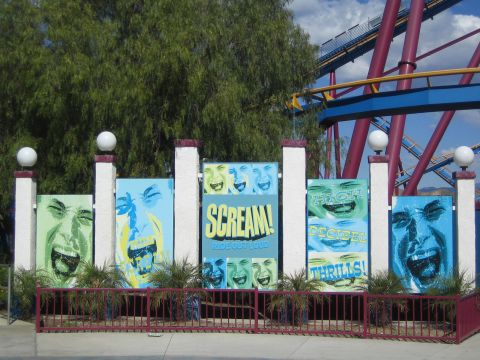 1990 Ford Bronco - row of painted panels showing screaming faces and the word SCREAM stands in front of a red-and-blue roller coaster.