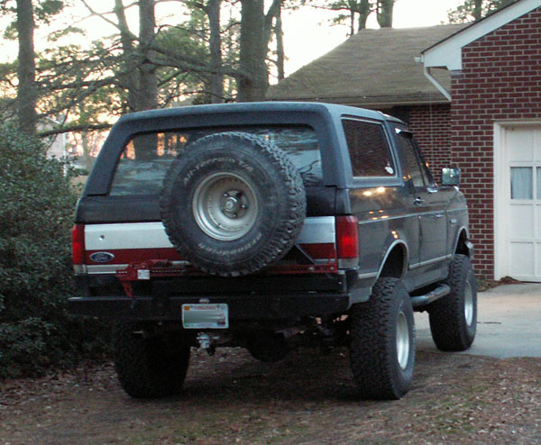 1988 Ford Bronco rear with spare tire mounted on tailgate, aftermarket bumper, and trailer hitch