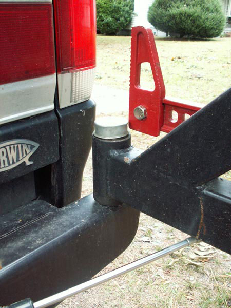 1988 Ford Bronco - Close-up of a vehicle's rear bumper, showing a mounted hi-lift jack accessory.
