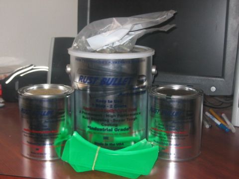 1991 Ford Bronco - Rust Bullet coating products are displayed on a desk next to a computer monitor.